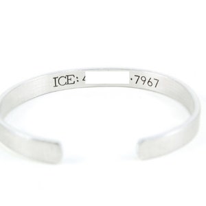 May include: Silver bangle bracelet with an inscription that reads "ICE: 4 .7967".