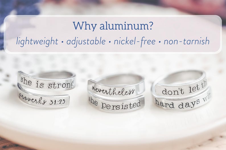 May include: Three silver-colored wrap rings with inspirational quotes. The rings are stamped with phrases like "she is strong" and "nevertheless she persisted." The image also includes text that says "Why aluminum?" and lists the benefits.