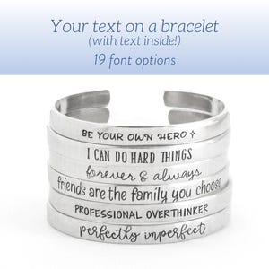 May include: A stack of silver bracelets with different inspirational messages engraved on them. The messages include "Be your own hero", "I can do hard things", "forever & always", "friends are the family you choose", "Professional overthinker", and "perfectly imperfect".