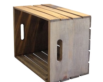 May include: A wooden crate with a rustic brown finish. The crate has two rectangular cutouts on the side and is made of natural wood.