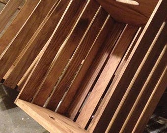 May include: A wooden crate with a rustic brown finish. The crate is made of slats of wood and has a rectangular shape. The crate is empty and ready to be filled.