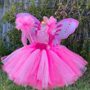 Błyszcząca różowa sukienka tutu wróżki: kwiatowe akcenty i skrzydła