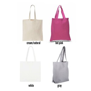 May include: Four tote bags in different colours: cream/natural, hot pink, white, and grey. The bags are made of canvas and have a simple design.