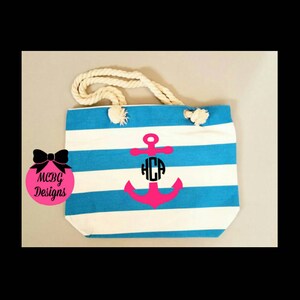 May include: A blue and white striped canvas tote bag with a pink anchor and a monogram "HCA" in a circle. The bag has rope handles.