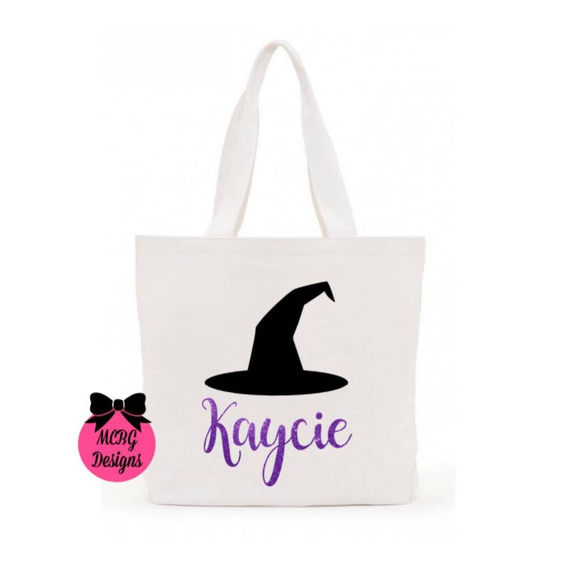 May include: White canvas tote bag with a black witch hat silhouette and the name "Kaycie" in purple glitter lettering.