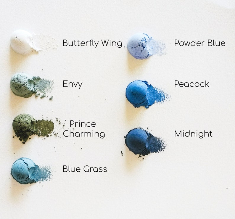 May include: Eight small round containers of blue, green, and white powder pigments. The containers are labelled with the names "Butterfly Wing", "Powder Blue", "Envy", "Peacock", "Prince Charming", "Midnight", "Blue Grass", and "White".