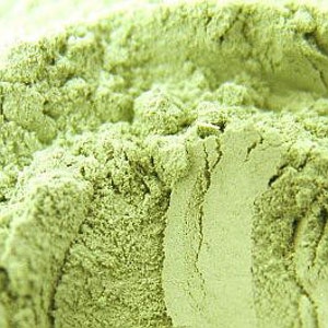 May include: Close-up of a pile of light green powder. The powder is fine and smooth, with a slightly grainy texture.