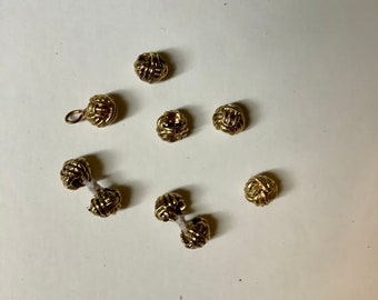 Messing Farbe Metall Liebhaber Knoten. Der letzte Besitzer dachte, sie sollten Manschettenknöpfe sein, wie es scheint. Die Fäden, die den Knoten bilden, sind gestreift.