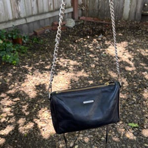 Bolso bandolera de piel negra estilo motero con 5 cremalleras de Rebecca Minkoff y herrajes plateados. imagen 4