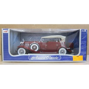 May include: A maroon 1932 Cadillac model car with white convertible top and white-walled tires. The model is in a clear plastic display case with the text "Anson Classic". The scale is 1:18.