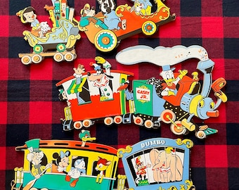 May include: A set of colorful wooden cutouts featuring Disney characters in a train theme. The train cars include Mickey Mouse, Donald Duck, Dumbo, and other figures. The engine is labeled Casey Jr. and one car is labeled Dumbo, with vibrant paint.