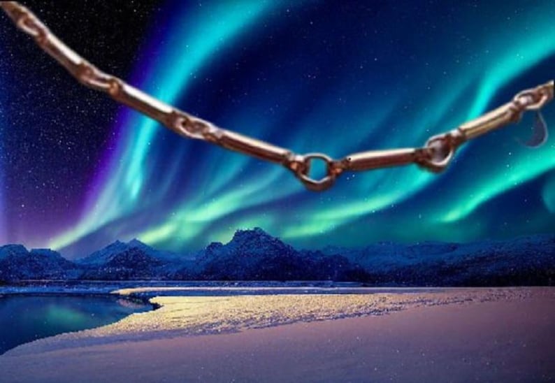 K&ouml;nnte beinhalten: Eine silberne Kettenkette mit einem einzigartigen Design h&auml;ngt vor dem Hintergrund eines leuchtenden Nordlichts &uuml;ber einer schneebedeckten Landschaft.