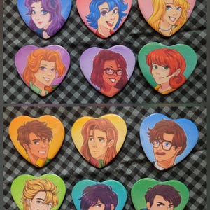 May include: A collection of heart-shaped pinback buttons featuring colorful illustrations of various characters. Each button showcases a different person with unique hairstyles and expressions, set against vibrant backgrounds.