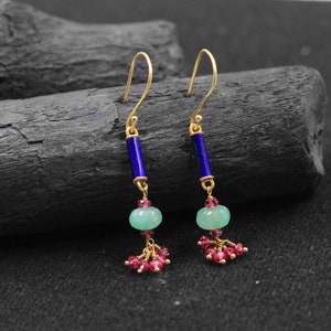 May include: Gold dangle earrings with blue and green gemstone beads and pink gemstone accents.
