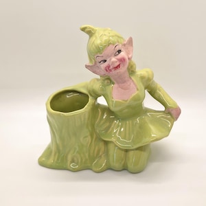 May include: A set of three ceramic mugs with a speckled, matte finish. The mugs are in shades of cream, light gray, and dark gray. Each mug has a simple, minimalist design, perfect for coffee or tea.