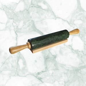 May include: A dark green marble rolling pin with light wood handles and a wooden base. The rolling pin is designed for kitchen use and is a stylish addition to any baker's tools.