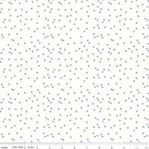 May include: Off-white fabric with a repeating pattern of small, navy blue circles. The fabric is measured in inches along the bottom edge, with the Riley Blake Designs logo visible.
