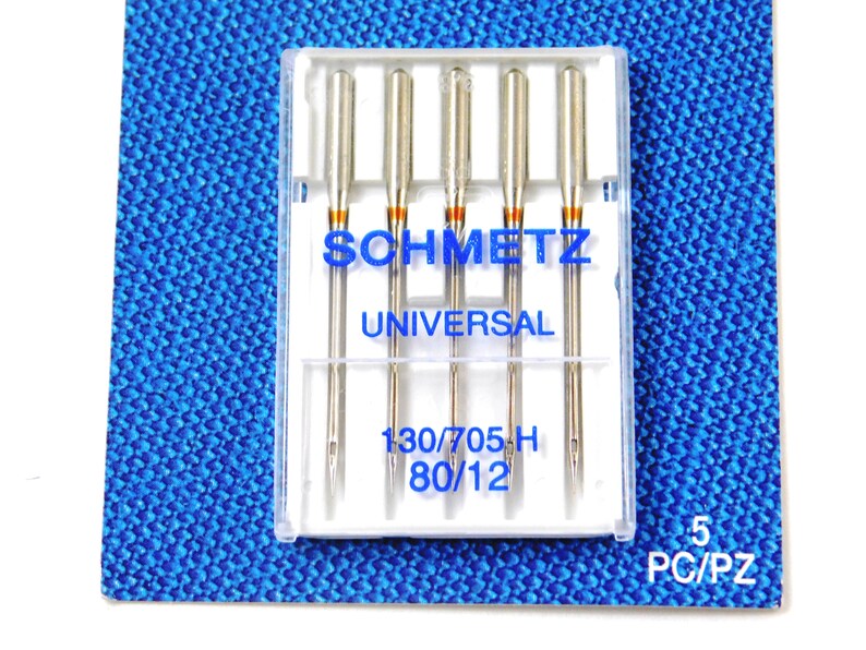 May include: A pack of five Schmetz Universal sewing machine needles in a clear plastic case. The needles are size 130/705H and 80/12.