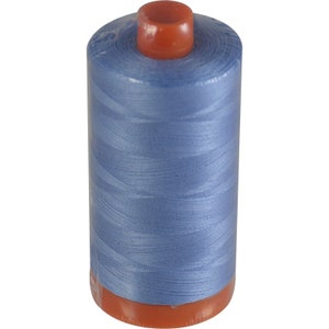 May include: A spool of light blue thread with an orange plastic bobbin.