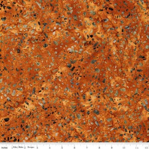 May include: Close-up of fabric with a mottled pattern in shades of orange, tan, and gray. The fabric has a speckled appearance, with small, irregular shapes scattered across the surface. The pattern is reminiscent of stone or a natural, organic texture. The fabric is measured in inches.