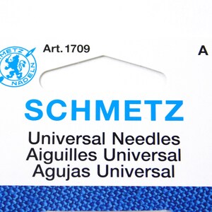 May include: A white package with blue text that reads "SCHMETZ Universal Needles Aiguilles Universal Agujas Universal" and a blue logo with a lion and the text "SCHMETZ NADELN" with the article number "Art. 1709" printed on the top. The package has a hole at the top for hanging.