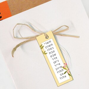 May include: A yellow bookmark with a floral design and Hebrew text that reads "Sheva Brachot" which translates to "Seven Blessings".