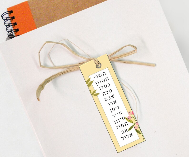 May include: A yellow bookmark with a floral design and Hebrew text that reads "Sheva Brachot" which translates to "Seven Blessings".