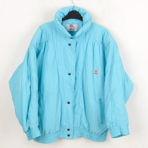 May include: A vintage turquoise puffer jacket with a high collar, snap closures, and a zipped pocket. The jacket has a ribbed hem and cuffs. A small logo is visible on the chest. The jacket is hanging on a black hanger.