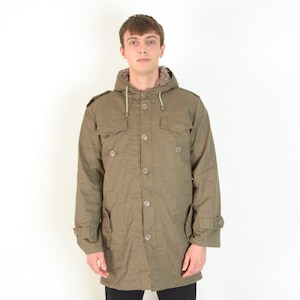 Op de afbeelding: Olijfgroene parka met capuchon, knoopsluiting, twee borstzakken en twee onderste zakken. De parka heeft een met bont gevoerde capuchon en verstelbare manchetten. Een jas in vintage militaire stijl.