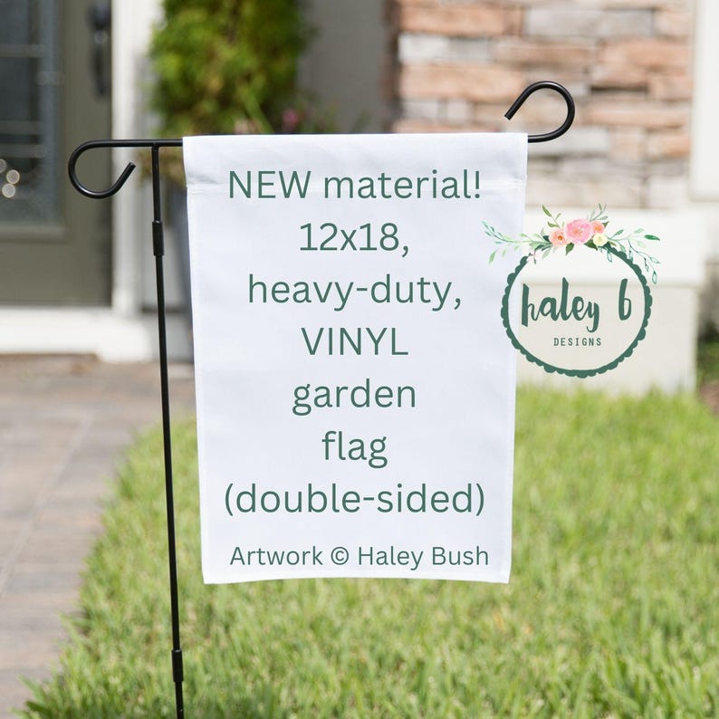 May include: A white vinyl garden flag, 12x18 inches, is displayed on a black metal stand. The flag reads "NEW material!" and "heavy-duty, VINYL garden flag (double-sided)." Artwork by Haley Bush.