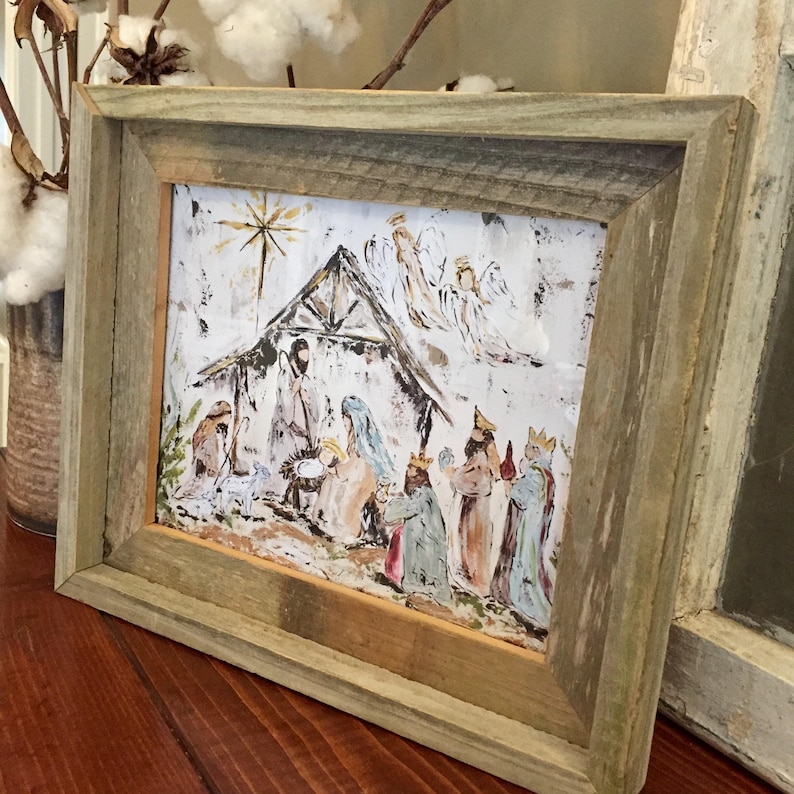 Puede incluir: Una pintura enmarcada de una escena de la natividad con un marco de madera r&uacute;stico. La pintura representa el nacimiento de Jes&uacute;s con &aacute;ngeles, pastores y magos. La pintura est&aacute; hecha en un estilo caprichoso con colores brillantes y un fondo texturizado.