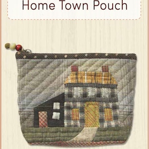 Puede incluir: Una bolsa acolchada con un diseño de casa con una puerta amarilla y un techo marrón. La bolsa tiene una cremallera y un borla marrón. El texto "Yoko Saito's Home Town Pouch" e "Includes Full-Size Pattern" está impreso en la imagen. El texto "ENGLISH EDITION!" también está impreso en la imagen.