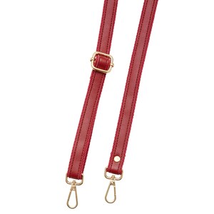 May include: Two red purse straps with gold-colored metal hardware. The straps have a stitched design and a buckle for adjustment. Each strap has a gold-colored clasp at the end for attachment.