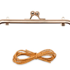 May include: Gold-toned metal purse frame with two round decorative knobs on top and a brown leather cord.
