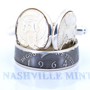 May include: Silver cufflinks made from a 1964 half dollar coin. The cufflinks feature the inscription "In God We Trust" and the year "1964". The cufflinks are made by Nashville Mint.