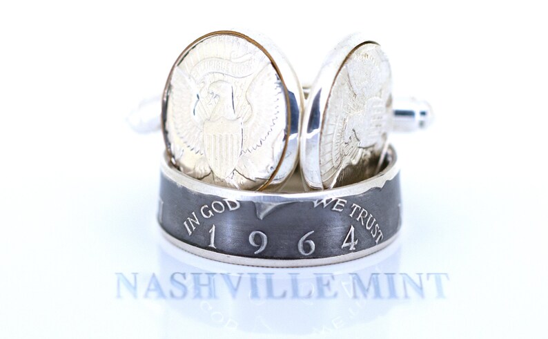 May include: Silver cufflinks made from a 1964 half dollar coin. The cufflinks feature the inscription "In God We Trust" and the year "1964". The cufflinks are made by Nashville Mint.