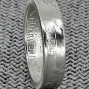 Può includere: Anello in moneta da un quarto di dollaro d'argento con l'iscrizione "IN GOD WE TRUST" e "QUARTER DOLLAR" sul lato. L'anno 1960 è visibile sull'anello.