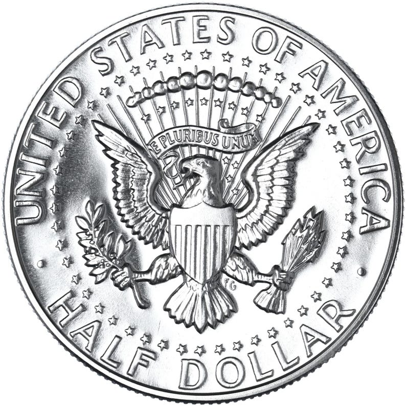 May include: A silver half dollar coin with the words "United States of America" and "Half Dollar" around the edge. The center of the coin features an eagle with a shield on its chest and a banner above it that reads "E Pluribus Unum".