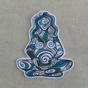 May include: Embroidered patch depicting a seated figure in meditation. The design uses swirling patterns in blue, green, and white, with black stitching. The patch has a white border and is suitable for clothing or accessories.
