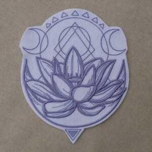 以下が含まれることがあります： 三日月と幾何学模様に囲まれた蓮の花のデザインが施された紫色の刺繍パッチ
