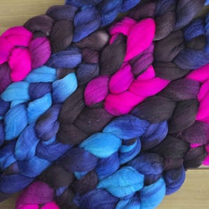 May include: A braided yarn with shades of dark blue, teal, purple, and hot pink.