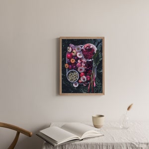 May include: A framed photograph of a platter of fruit, including red apples, plums, cherries, and peaches, arranged on a bed of green leaves.