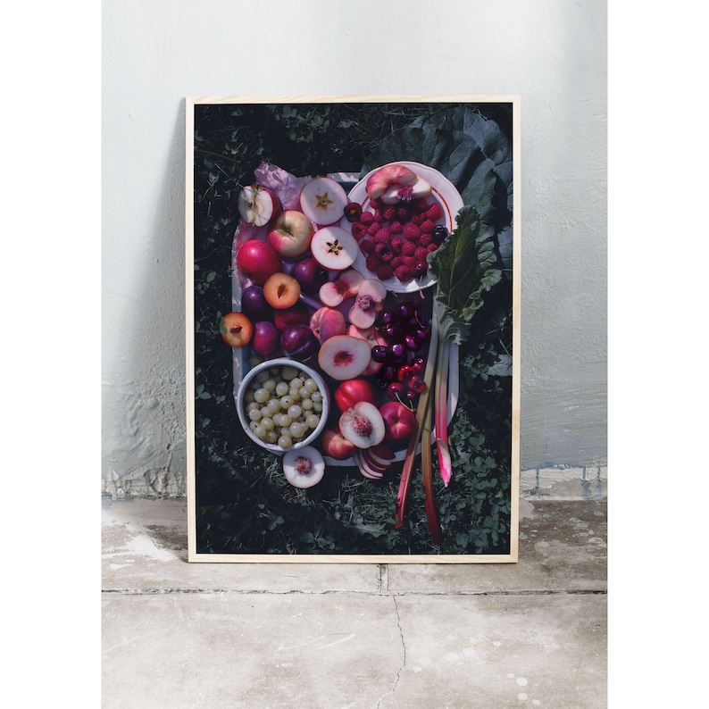 May include: A white plate filled with a variety of fresh fruit, including red cherries, sliced peaches, plums, and red raspberries. The fruit is arranged in a colorful and appetizing display.