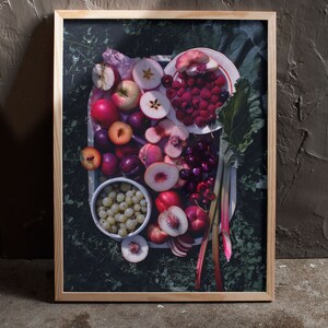 May include: A framed photograph of a tray of fresh fruit, including peaches, plums, cherries, raspberries, and apples. The fruit is arranged on a white plate with green leaves and rhubarb stalks.