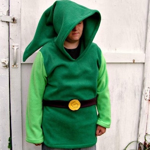 May include: A green hooded sweatshirt with a pointed hood and a black belt with a gold buckle. The sleeves are a lighter shade of green.