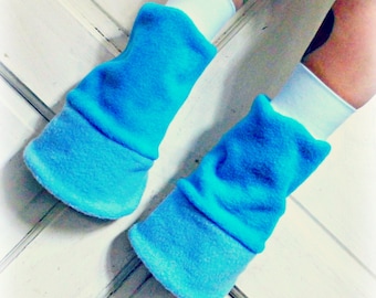 May include: A pair of bright blue fleece leg warmers with a folded cuff. The leg warmers are worn on a person's legs.