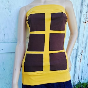 May include: A yellow and brown tube top with a geometric design. The top features a yellow base with brown rectangular panels outlined in yellow. The garment is displayed on a mannequin.