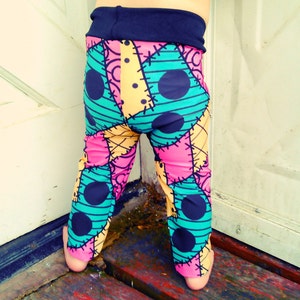 Könnte beinhalten: Eine bunte Leggings mit Patchwork-Muster, schwarzen Punkten und sichtbaren Nähten. Die Leggings ist aus weichem, dehnbarem Stoff und perfekt für den Alltag.