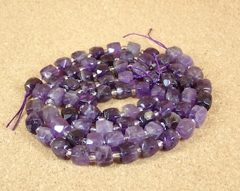 Può includere: Una collana di perle di ametista viola, ogni perla è sfaccettata e ha una forma quadrata. Le perle sono infilate su un filo d'argento.