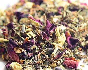 May include: A close-up shot of a mix of dried herbs and flowers. The blend features deep purple rose petals, lavender, and green leaves. Yellow and beige flower buds are also present, creating a colourful and textured mix.